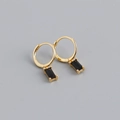 Gros plan sur des boucles d'oreilles dorées avec un zircon noir rectangulaire - Or, Pierre Noire