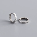 Macro shot of S925 sterling silver hoop earrings with geometric diamond-cut patterns - 925 Silver / White Gold