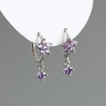 Détail macro de boucles d'oreilles fleur de prunier avec zircons violets sur support - Violet (Argent)