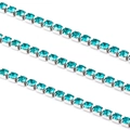 Vue macro des chaînes de griffes en strass turquoise avec monture argentée à quatre griffes - Vert Paon