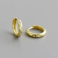 Macro shot of S925 sterling silver stamp and geometric texture on gold huggie earrings - Gold (White Stone)