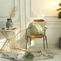 Grass green teddy fleece throw pillow placed on a wooden chair in a modern living room - Avocado Green