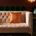Modern orange satin cushion cover with gold geometric patterns on a luxury velvet sofa - Golden Geometric Rings (3)