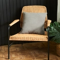 Grey square decorative pillow cover with embossed dotted texture on a rattan chair - Gray