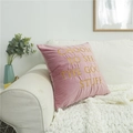 Pink velvet pillow cover with gold embroidery text on a stylish white sofa - Pink