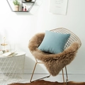 Couverture en fausse fourrure marron et coussin bleu clair sur une chaise dorée - 45x45cm (Avec Noyau 400g) / Bleu Brume