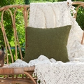 Donkergroene kussensloop van dikke chenille met textuur op een bruine rieten stoel - 45x45 / Met Vulling / Mosgroen