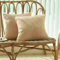 Set of two orange and white herringbone knit pillow covers on a cozy rattan bench - Milk Tea