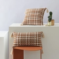 Bohemian rust red and white woven pillow cover with tassels in a minimalist setting - Tobacco Brown