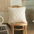 Cream white plush pillow cover with geometric diamond tufted pattern on a wooden chair - Milk White