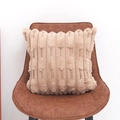 Federa cuscino kaki in finta pelliccia con trama a spighe su una sedia in pelle - 45x45 / Senza Anima / Caffè Chiaro