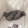Dettaglio di un cuscino a nodo grigio scuro in ciniglia su un divano color crema - 400g / grigio scuro