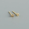Macro shot of minimalist gold studs featuring square pink zircon stones on grey background - Square Pink Zirconia (Gold) / 925 Silver