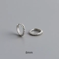 Detail view of 8mm S925 sterling silver hoop earrings featuring beaded texture and hallmarking - Inner Diameter 8mm / White Gold