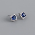 Macro detail of square blue zircon earrings with a sparkling diamond halo setting - Blue Stone (Platinum)