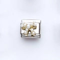 Macro shot of stainless steel Italian charm link with golden pearl bow detail - Bow