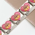 Vue macro d'un maillon modulaire en acier avec cœur émaillé rose et empreinte CAT - Style CAT Patte de Chat