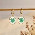 Golden hoop earrings featuring a white round pendant with a green lucky clover charm - Four-leaf Clover Style