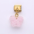 Detail eines rosa Glitzer-Schmetterlingsanhängers an einem goldenen italienischen Armbandlink - Irisierendes Rosa Schmetterling Stil