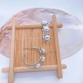 Detailed view of silver flower earrings with white pearls on a natural shell background - Silver Earrings (No Pearl)