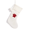 Cream knit Christmas stocking featuring a red paw print pattern and white pom poms - White Paw