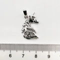 Detail view of silver unicorn charm with zircons beside a ruler for size measurement - Unicorn / White Gold