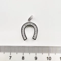 Détail d'un pendentif fer à cheval de 1,5 cm serti de zircons sur fond blanc épuré - Fer à Cheval / Or blanc