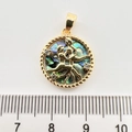Makroaufnahme eines 2,5cm runden Abalone-Anhängers mit goldenem Relief der Verliebten - Zwillinge Abalone-Schale