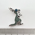 Macro shot of a silver dinosaur pendant with green zircons and blue eye detailing - Silver Dinosaur