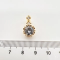 Makroansicht des goldenen Anhängers mit klaren Zirkonsteinen und Messskala - Runder Anhänger Ohne Kette / 18K-Gold