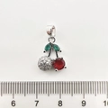 Détail d'un pendentif cerise avec rubis rouges et feuilles vertes à côté d'une règle - Cerise / Or blanc