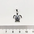 Vue détaillée du pendentif tortue en argent avec gemme bleue et mesure à la règle - Tortue de mer / Or blanc
