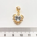 Gros plan du pendentif cœur doré avec cristal, détails de rose et règle de mesure - Cœur Or 18K