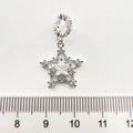 Macro d'un pendentif étoile en argent avec zircons et règle pour la taille réelle - Étoile Or Blanc