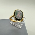 Dettaglio macro di un anello in oro 18 carati con una grande madreperla nera ovale iridescente - Anello Aperto Regolabile in Conchiglia di Abalone Ovale