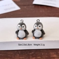Detail van schattige geflokte pinguïnhangers met afmetingen voor DIY-sieradenprojecten - Handopstekende Pinguïn