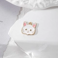 Détail d'un mignon pendentif chat en émail avec bords dorés sur pierre texturée pour DIY - Chat Blanc avec Moustaches