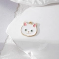 Detail eines weißen Emaille-Kätzchen-Anhängers mit Goldrand und blauen Augen für DIY-Schmuck - Weiße Katze mit blauen Augen