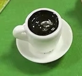 Miniature white resin coffee cup charm with black liquid and metal ring on green base - White Cup