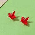 Macro shot of glossy red resin origami crane charms with silver rings for DIY jewelry - Red Paper Crane