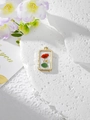 Detailed close-up of golden resin pendant with red dried flowers on a white stone background - 1 Red White Floral