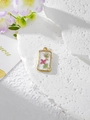 Close-up of golden rectangular resin pendant with pink dried flowers on stone background - 4 White Rose Red Floral