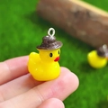 Mini hars geel eendje bedeltje met bruine hoed en metalen ring in de hand - Gele Eend Met Hoed