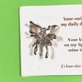 Detailed macro view of silver liquid metal butterfly pendant with pink gemstone inlay - Pink