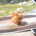 Close-up of cute orange flocked cat charm with silver metal ring on a wooden tray - Running Fox