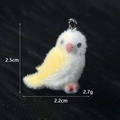 Dettaglio ciondolo uccello floccato che mostra altezza 2,5 cm e larghezza 2,2 cm su tessuto - Pappagallo Giallo