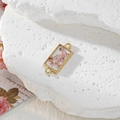 Macro shot of gold geometric pendant featuring pink dried flowers in resin with dual rings - Rectangle Pink Flower