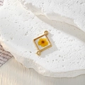 Dettaglio del ciondolo geometrico dorato con un vero fiore giallo essiccato in resina - Fiore Giallo Quadrato