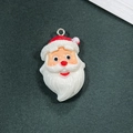 Dettaglio di un ciondolo natalizio fai-da-te in resina con colori vivaci e anello - Stile Testa Babbo Natale