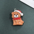 Dettaglio di un ciondolo natalizio in resina con cappello rosso e anello in argento - Stile Cucciolo di Natale